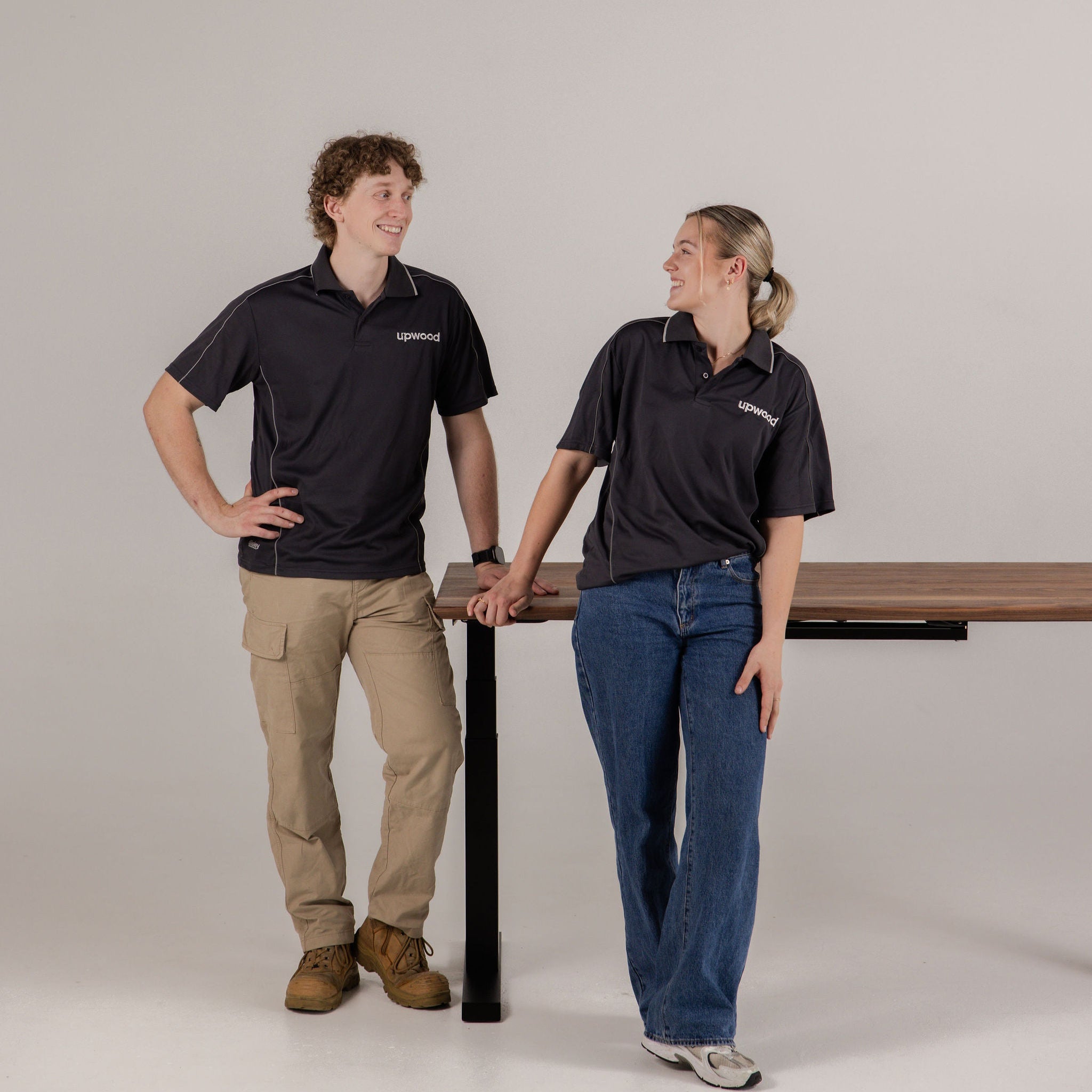 Upwood's founders alongside their handcrafted height-adjustable standing desk, showcasing Australian craftsmanship in Port Adelaide